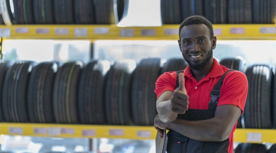 Automonteur met een rood shirt Bandenmonteur aan het werk
